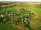 Top view of the village with wooden houses in wild among the forest and field. Aerial view of country house in countryside. Roofs