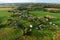 Top view of the village with wooden houses in wild among the forest and field. Aerial view of country house in countryside. Roofs