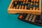 Top view of vintage abacus and modern calculator on a green background, the concept of finance and mathematical calculations