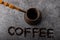 Top view of vintage cezve with coffee and lettering `coffee` with ground coffee under the cezve on grey background