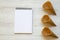 Top view, waffle sweet cones with notebook on a white wooden background. From above.