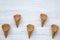 Top view, waffle sweet cones on a white wooden background. From above.