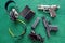 Top view weapons : Two pistols, Ear Muffs and bullets and Semi-automatic gun for self-defense on green table