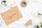 Top view wedding feminine accessories on marble background. Minimal flat lay style composition with craft paper envelope, twine,
