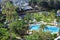 Top view of the well-kept hotel grounds with pools, sun loungers and trees
