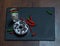 top view on a white coconut drink decorated with two red and green peppers, dessert donut with cream, whole black stone plate, on