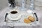 Top view of a white cup of coffee and curd cookies on a handmade wooden tray