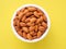 Top view of white cups, bowls with a handful of pecans, almonds