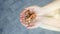 Top view of white hands holding cookies split in several pieces in black paved street floor background. Unhealthy food concept.