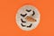 Top view of white Japanese Hokkaido quash with bats on orange background