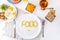 Top view white plate with Food word lettering by vitamin pills on the served wooden table with breakfast meal. Pill instead of foo