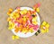 Top view of a white plate full of colorful Italian ravioli pasta on a canvas
