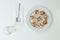 Top view of a white plate of mini pizza bagels on white background