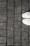 Top view of white sneakers and gray cobblestone pavement. Gray stone pavement background