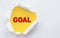 Top view of white torn paper and the text GOAL on a yellow background