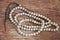 Top view of white wooden buddhist bracelet on wooden background.