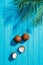 top view of whole and cracked coconuts and green palm leaves on blue