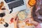 Top view Woman eating popcorn while watching Halloween movie. Laptop, popcorn bowl, pumpkin, bats, ghost silhouettes