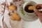 Top view of woman hand holding cookies, warm tea cup on table
