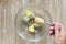 Top view of woman hand holding spoon with mustard to put it into boiled yolks for making flavoring for okroshka