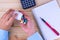 Top view of woman hands holding white bottle pill to taking medication with book and pen on wooden table. Hard working and