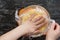 Top view of woman hands placing piece of plastic wrap directly over surface of custard cream on the black background