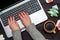 Top view of woman hands typing on open laptop keyboard on table with Cristmas decorations, copy space.