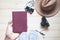 Top view woman holding passport book with cameras and hat on wooden floor. Travel lifestyle