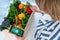 Top view woman holding wooden box with fresh vegetables and phone with active online mobile application with Vegitarian