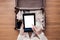 Top view of woman packing a luggage for a new journey. Female standing above suitcase with electronic note pad and cup of coffee.