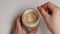 Top view of woman person hand stirring latte coffee with glass spoon