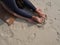 Top view of woman practicing plow yoga pose lying at mat at sandy beach