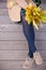 Top view on woman`s hands holding beautiful bunch of yellow marple leaves. Young woman with bouquet of autumn leaves