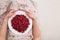 Top view on woman sitting cozy on the couch and enjoying delicious summer berries. Girl holding white plate