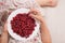 Top view on woman sitting cozy on the couch and enjoying delicious summer berries. Girl holding white plate