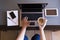 Top view of woman working on laptop with cup of coffee, smartphone, tablet and notebook. Indoors. Work space