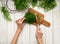 Top view of a womans hand, fresh dill on a cutting board, knife and bunches of dill on a white wooden table. Fresh greens, seaso