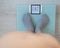 Top view of women`s feet in gray socks on a floor scale. The inscription on the screen is fat. An obese man measures his