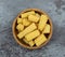 Top view of a wood bowl filled with canned organic baby corn on a gray background