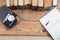 Top view on wooden desktop with books, notepad and camera