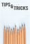 Top view of wooden pencils with word Tips and tricks on paper