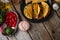 Top view of wooden rustic table with plate with tacos, metal dish with vegetables, salt in glass bowl and other ingredients for