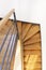 Top view of a wooden staircase with white wall and metal railing