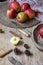 Top view of wooden table with red apples, kitchen utensils, cinnamon, flour and tablecloth