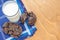 Top view on wooden table served with dark blue dinner napkin and glass of fresh milk with a group of baked choco sweet biscuits.