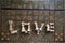 Top view of the word Love from chess pieces on an inlaid chessboard, selective focus