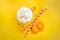 Top view of yellow coffee cup, straws and french macaroons over yellow background.