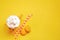 Top view of yellow coffee cup, straws and french macaroons over yellow background.