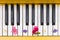 Top view on yellow piano. Closeup of piano keys with nice bright flowers. Music concept