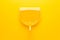 Top view of yellow plastic dustpan. minimalistic photo of dustpan on yellow background